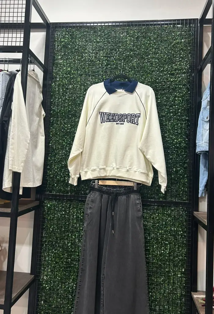 Look de temporada en Rústica: buzo crudo con cuello azul y pantalón wide leg gris