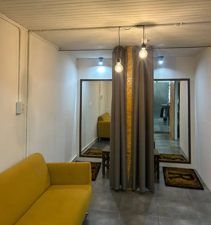 Probadores de Rústica con espejos grandes, cortinas y un sillón amarillo